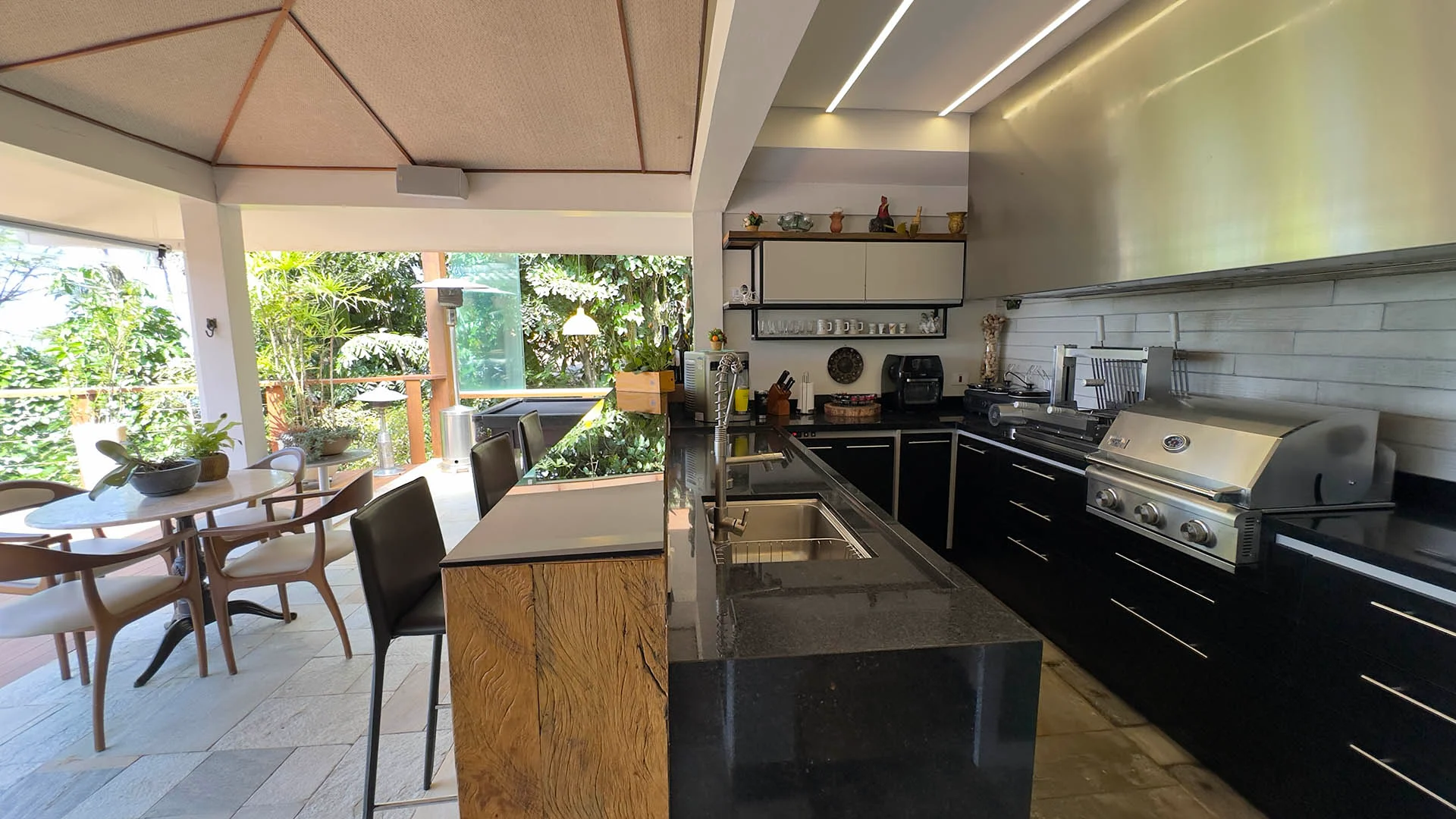 Cozinha gourmet com bancada de granito e churrasqueira profissional
