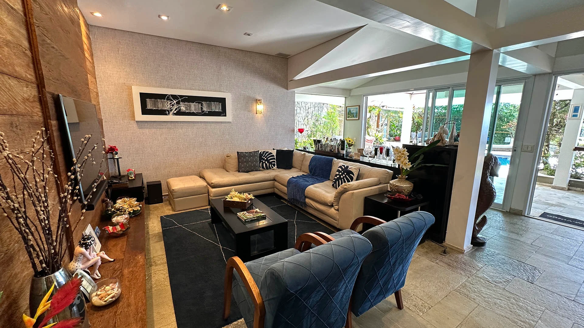 Sala de TV com sofa para 5 lugares chaise e duas poltronas e painel de madeira