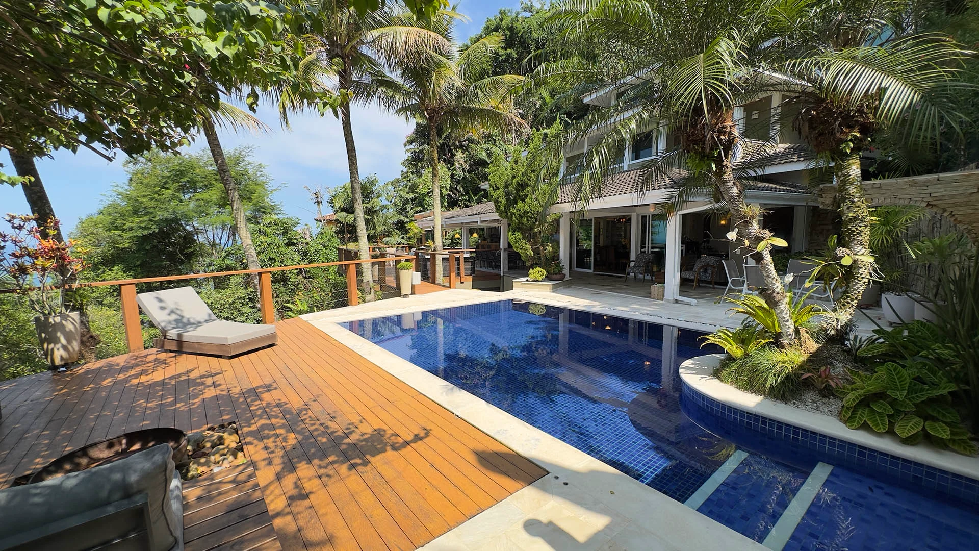 Destaque da fachada da casa com piscina aquecida espreguiçadeira lareira de chão e ilha de paisagismo