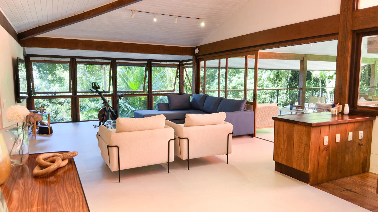 Villa 207 - Aluguel Temporada - Sala de estar com TV e vista o paisagismo e a mata  no conodmínio Tijucopava